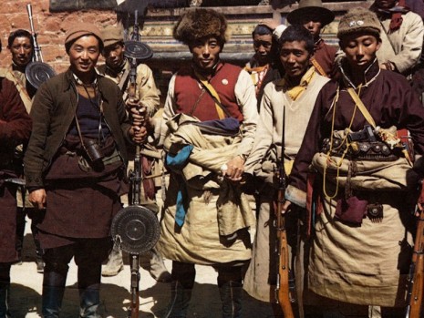 Ratuk Ngawang la at Tsetang. He is holding a captured Russian DP-28 light machine gun with circular pan magazine. Tibetans called it chikhang. To his right is the war photographer, Tsongon Jhanjup Jinpa.